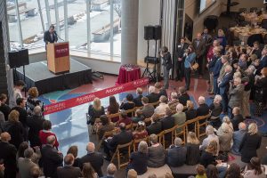 Photograph of President Paul Pribbenow at a podium discussing the opening with a large crowd.