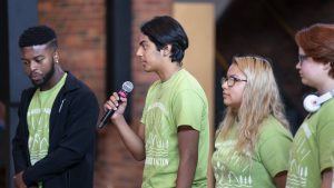 4 AYTI participants with 1 of them speaking into a microphone
