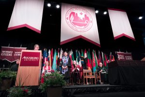 Flags representing American Indian and International students graduating in ceremony.