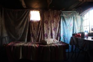 a small room with floral sheets draped over the walls