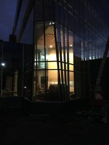 An exterior view of the illuminated Hagfors Center lobby.