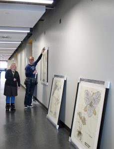 Art installation with some pieces hanging, others on the floor ready to be installed