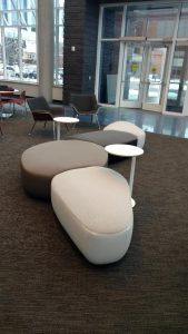 Upholstered seating with no backs and small round tables