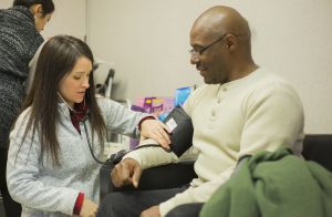 nurse performs blood pressure check