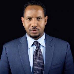 Abdirahman Mukhtar poses in a blue suit