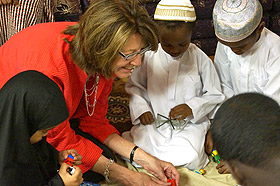 DHS Commissioner Lucinda Jesson (second from left) plays with Fadumo Aden, Abdullahi Hersi and Muhamed Hersi (left to right) at Health Commons in Minneapolis' Cedar-Riverside neighborhood while their mothers attend a nutrition class at the center.