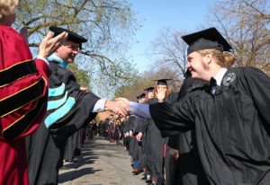 English major Connor Doebbert shaking hands with Prof. George Dierberger at Augsburg's 2017 spring commencement.