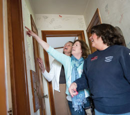 Former and current staff members reminisce over a collage of names written within one of Augsburg’s former houses.