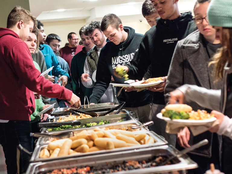 Augsburg student-athletes dish up food at a buffet