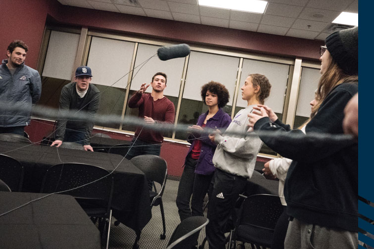 Augsburg student-athletes work together to solve a puzzle with yarn