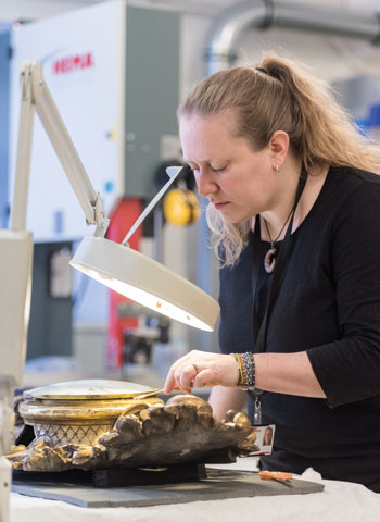 Juliane Derry ’00 works on an artifact from Norway’s national collection.