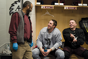 Minasie laughs with men's hockey players