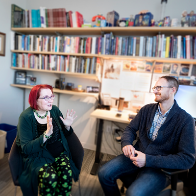 Professor Bridget Robinson-Riegler, left, talking to Assistant Professor Ben Denkinger in his office