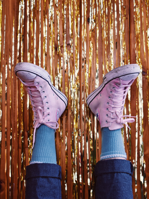 Feet in the air with pink Converse on