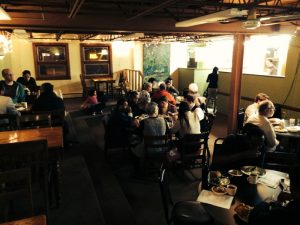 People sitting around tables in Cedar Commons sharing a meal.