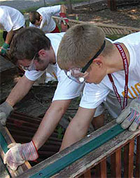 Students work on a renovation project wearing gloves and goggles