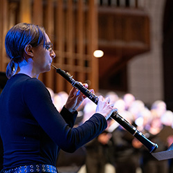 A student playing the flute at Advent Vespers