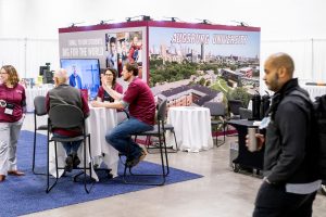 people speaking at the Augsburg booth during The Forum