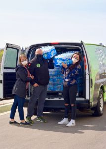 Bethany loading water bottles into van