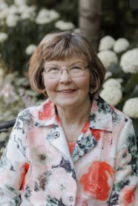 Evangeline Hagfors smiles in front of flowers for the photo