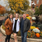 Three people standing in front of a fall display