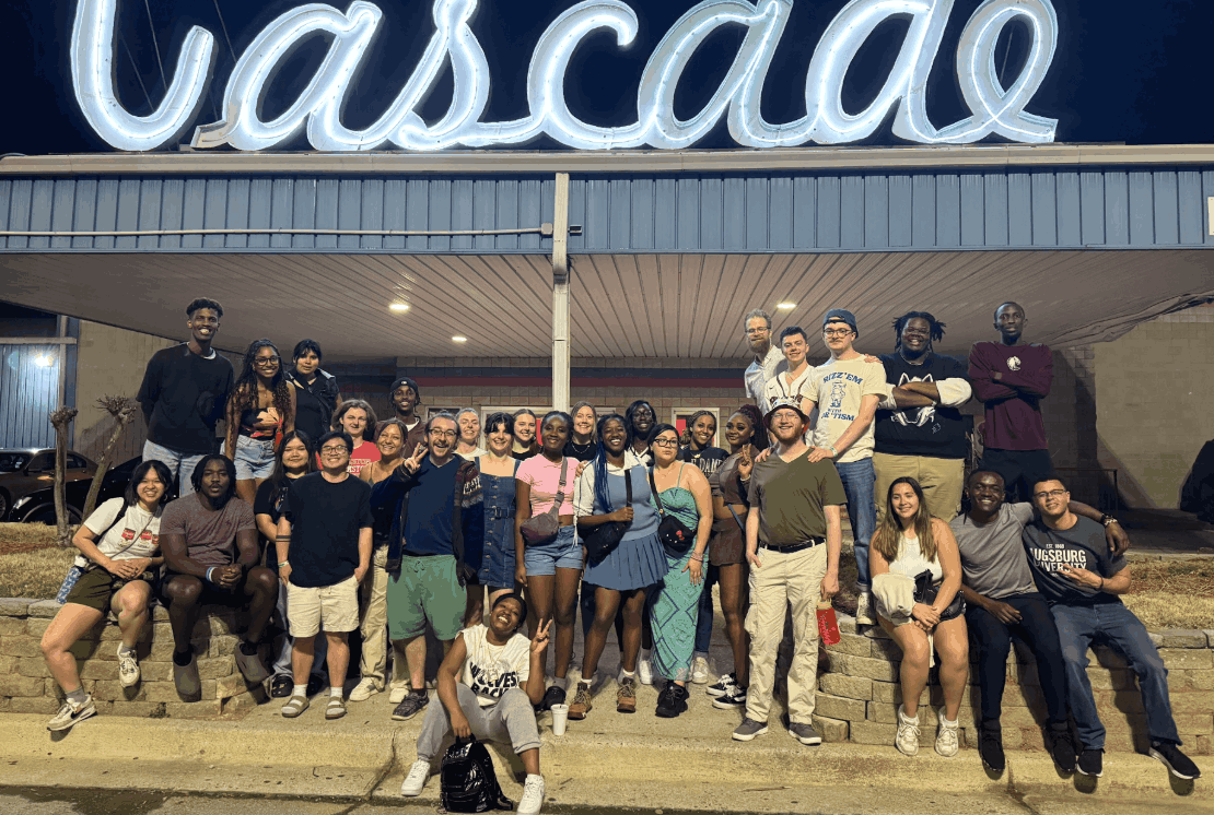 Many students are posed together in front of the Cascade in Atlanta on an Alternative Spring Break trip.