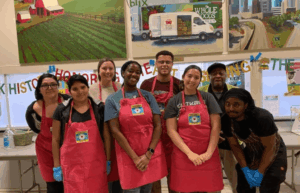 Students wearing red aprons, pose together at an Atlanta community service site during their Alternative Spring Break trip.
