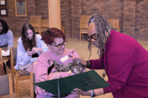 Pastor Babette Chatman blesses the cat of Pastoral Intern Sarah Root.