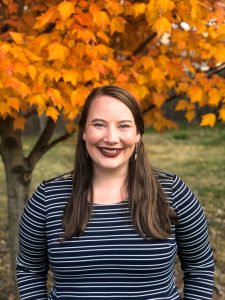 headshot of Amanda smiling with tree in background