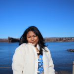 Headshot of Grace Koch Muchahary standing in front of a body of water