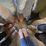 A circle of the CCV staff's feet. Some have shoes on and some just have socks. 