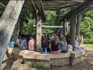 Students gathered around while Jim Bear Jacobs is sharing stories.