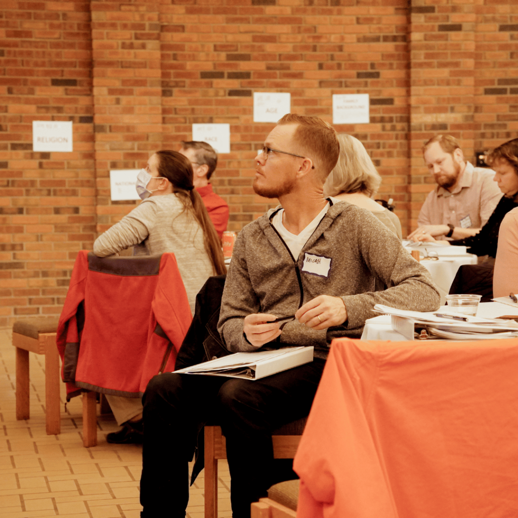 A member of the community at a table facing the speakers