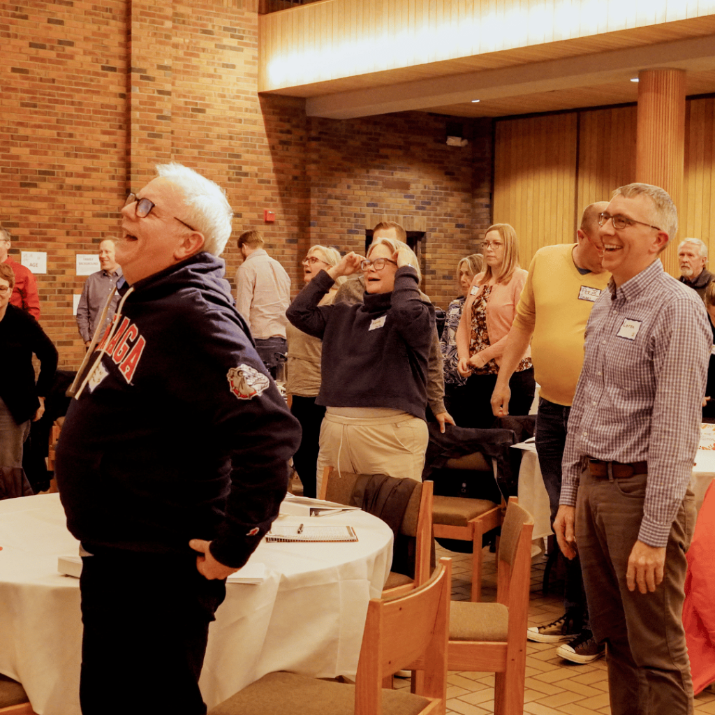 The large group standing up laughing.