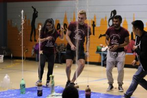 soda bottles spraying upward, students running away