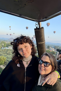 Student artist and their mother posing in a hot air balloon.