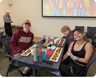 StepUP scholars sitting at a table with wings.