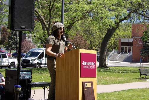 Treu speaking at a podium