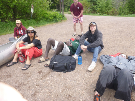 StepUP scholars in rain gear laying tuckered out on the beach
