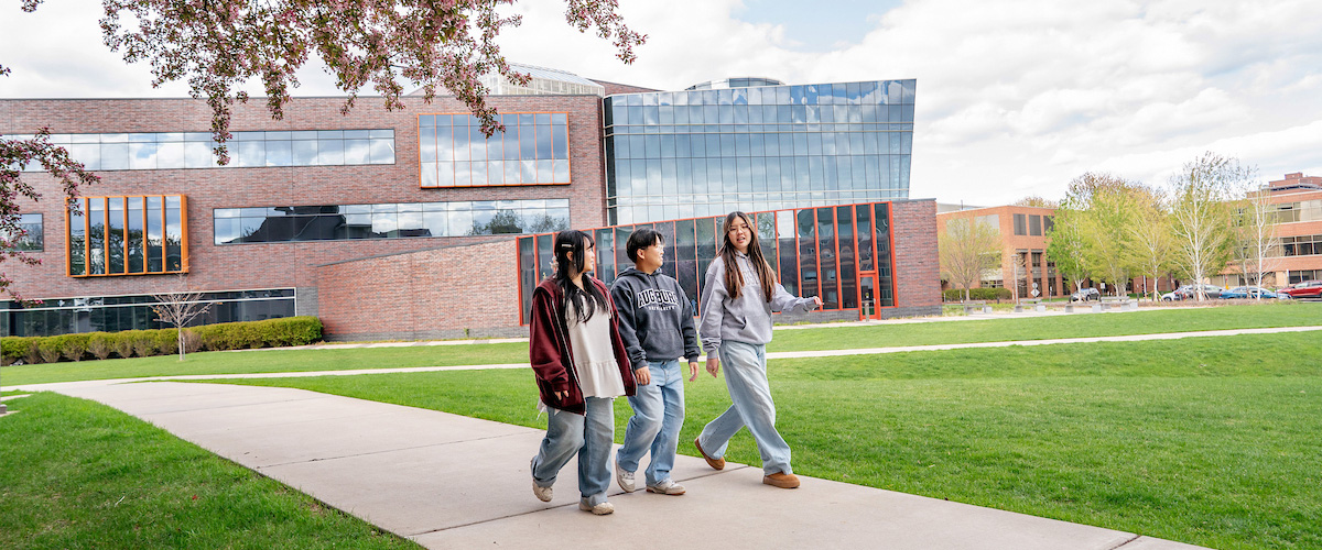 Three students walking around the Augsburg campus