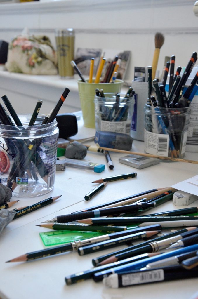 Brushes and pencils scattered on a desk