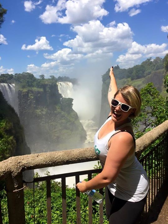 Student poses at waterfalls