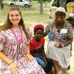 a mother and young son sit smiling with a student