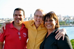 group of three people smiling with arms around one another