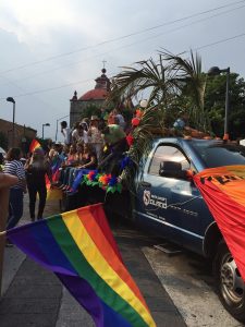 a truck drives in the parade with people riding in the back