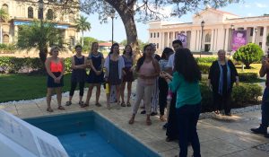 group of college students listen to professor with large Nicaraguan buildings in background