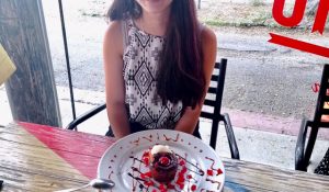 a young woman in a restaurant with a dessert