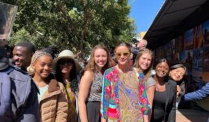 a group of young women smiling at the camera in a crowd