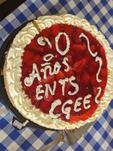 a round red cake with icing that reads 20 anos ents cgee