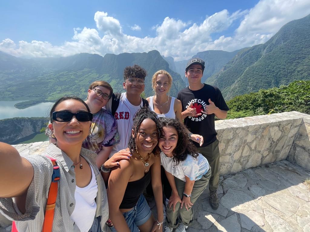 Group of 7 college students in front of a volcano